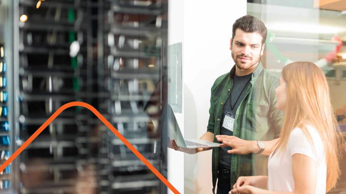 Technician and worker talking holding computer in office